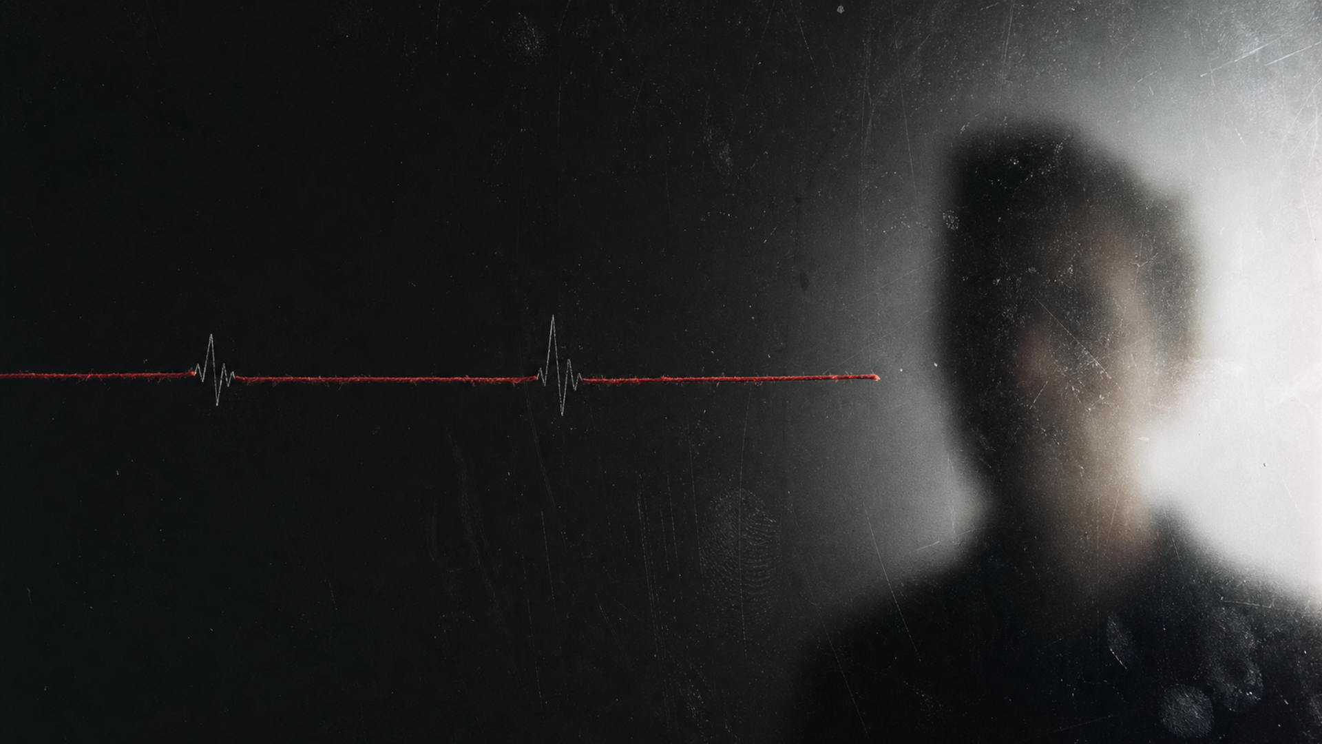 A blurred face occupies the right side of a scratched widescreen glass panel while a red thread crosses two waveform marks.